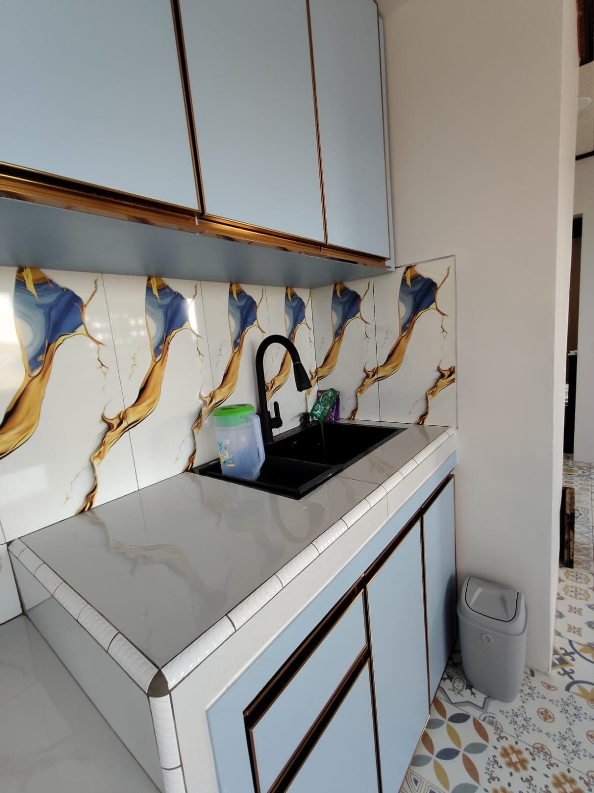 Dapur bersama dengan sink, kabinet atas, dan keran modern